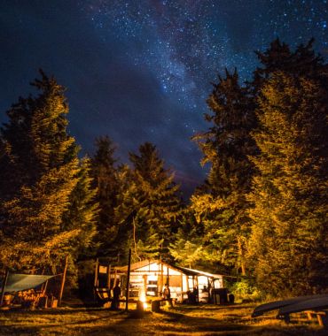 dining and activity shelter lit up under starry sky