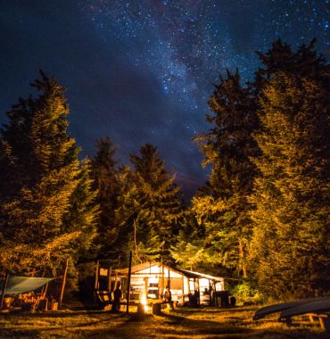 image by Mike Byrne dining and activity shelter lit up under starry sky