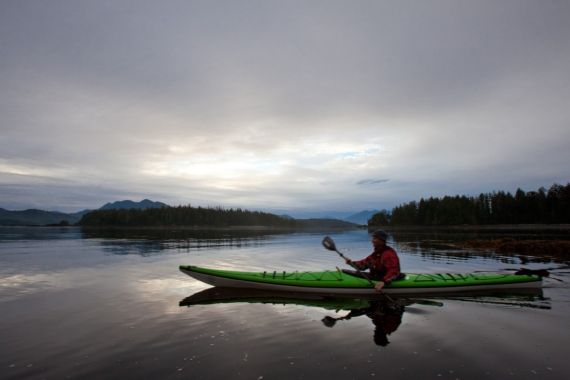 sea kayaker at sunsrise in calm bay at Spring Island